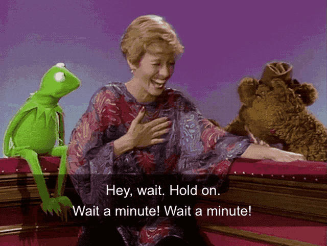 kermit the frog sits on a woman 's lap and says hey wait hold on wait a minute