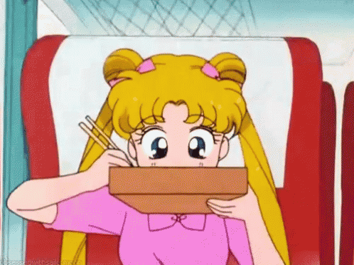 a girl in a pink shirt is eating something with chopsticks .