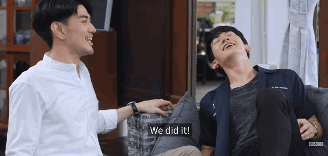two young men are sitting on a couch and one of them says we did it .