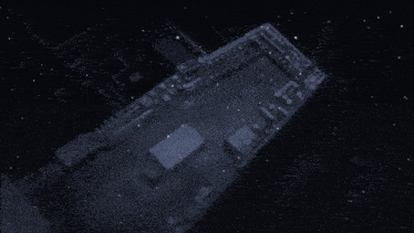 an aerial view of a building at night with snow on the ground