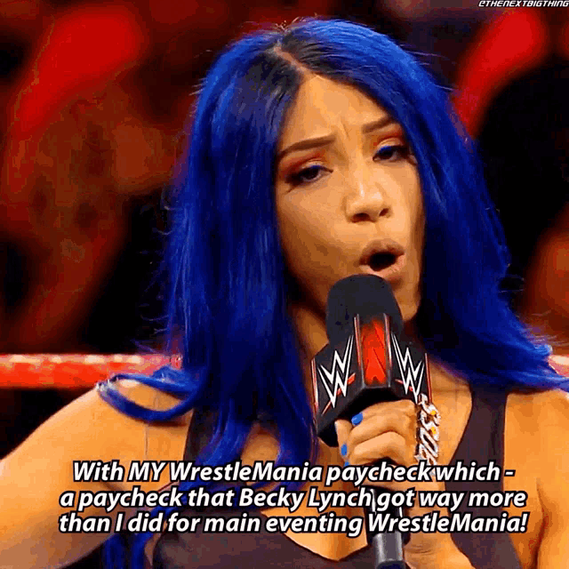 a woman with blue hair is talking into a microphone and says with my wrestlemania paycheck