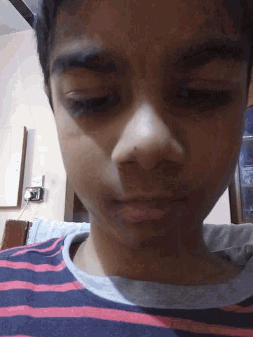 a close up of a person 's face with a striped shirt