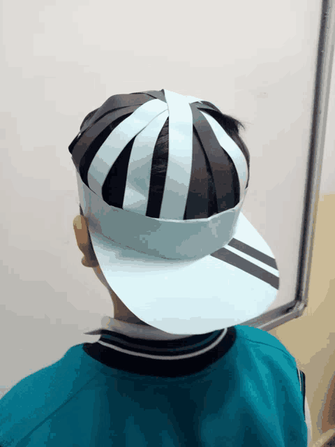 a person wearing a paper hat with black and white stripes on it
