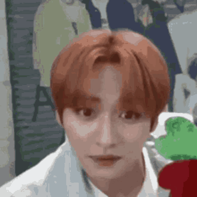 a young man with red hair is making a funny face .