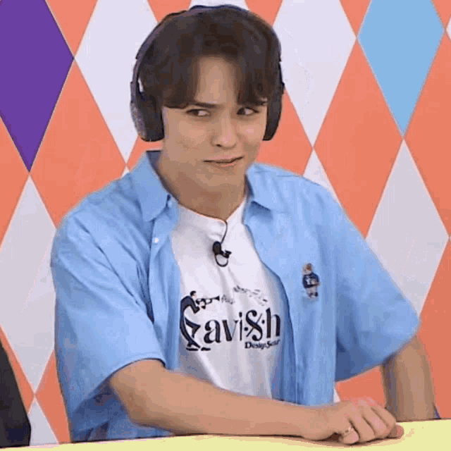 a young man wearing headphones is sitting at a table .