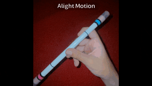 a person is holding a pen with the words alight motion written on the bottom