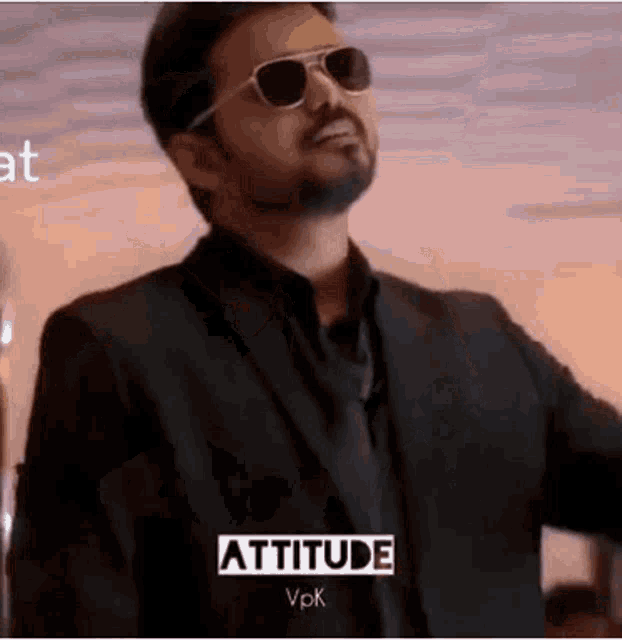 a man in a suit and tie is wearing sunglasses and a black jacket .