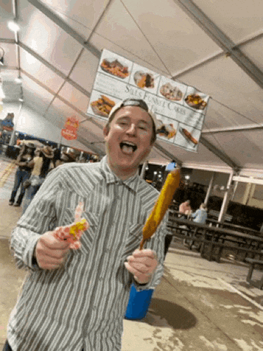 a man is holding a corn on the cob in front of a sign that says salt funky cakes
