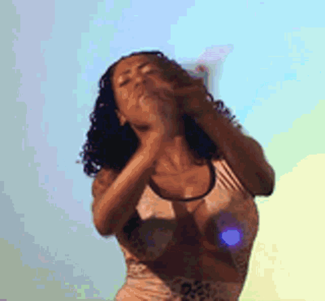 a woman with curly hair is blowing a kiss