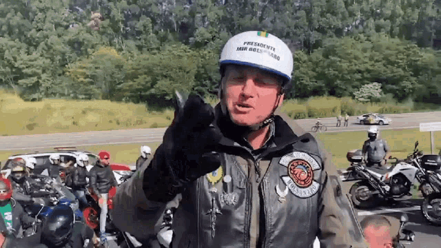 a man wearing a white helmet which says presidente on it