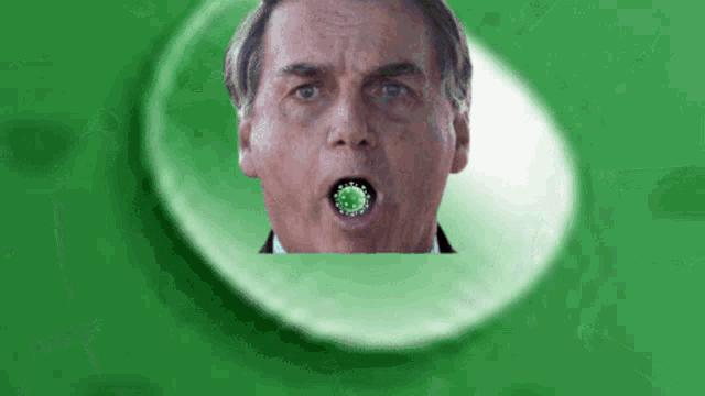 a close up of a man with a green circle in his mouth