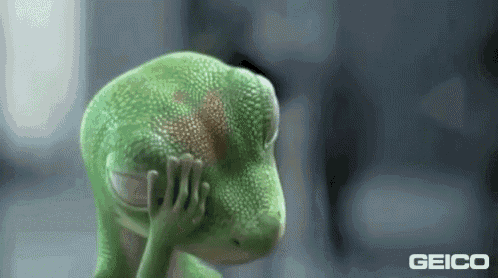 a green lizard is covering its face with its hand in a geico ad .