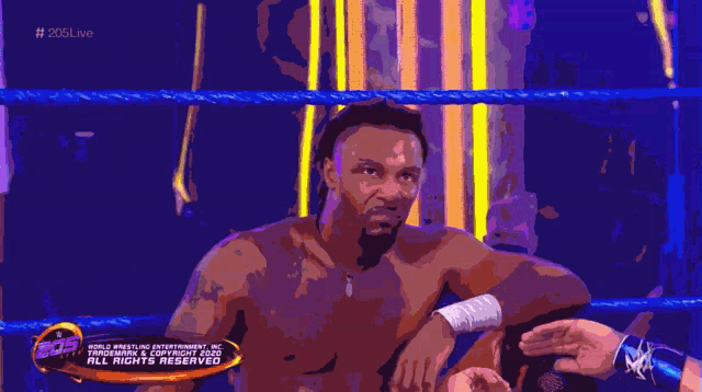 a man sitting in a wrestling ring with a banner that says all rights reserved
