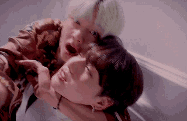 a man with green hair is hugging another man