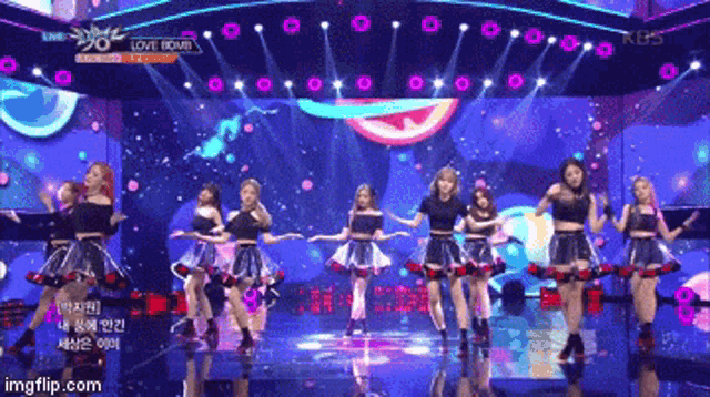 a group of girls are dancing on a stage with the words love bomb on the bottom