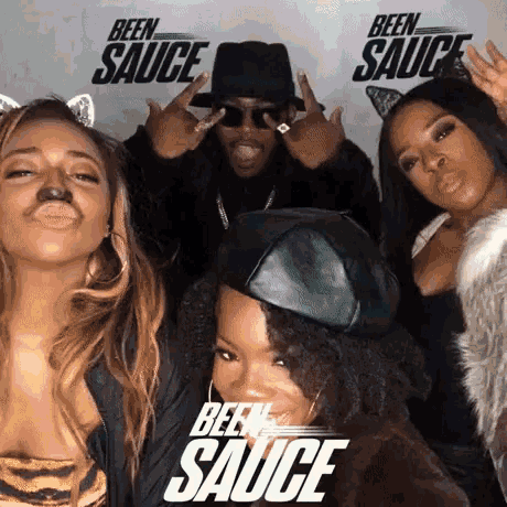 a group of people are posing for a picture in front of signs that say been sauce