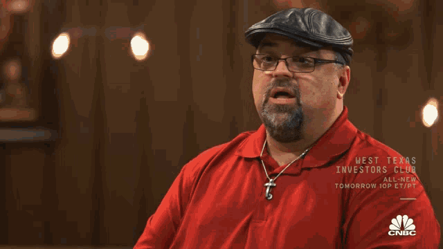 a man wearing a red shirt with cnbc on the sleeve