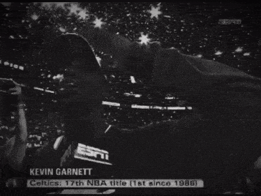kevin garnett holds a trophy in front of a crowd of fans