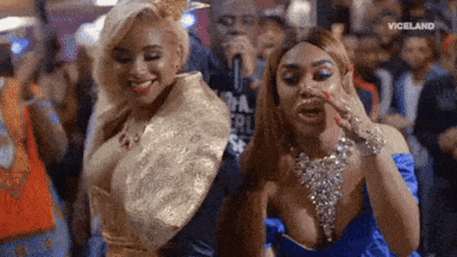 two women are standing next to each other at a party .