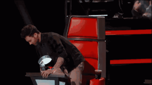 a man is sitting in a red chair with his arms crossed