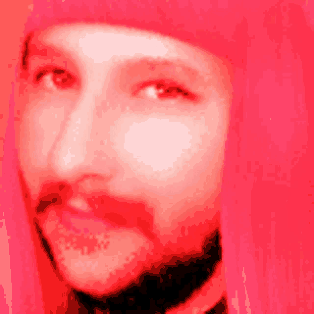 a man with a beard is wearing a red hat