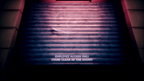 a staircase with a sign that says " employee access only stand clear of the doors "