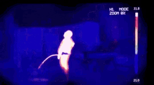 a thermal image of a person standing next to a fire with a zoom of 8 %
