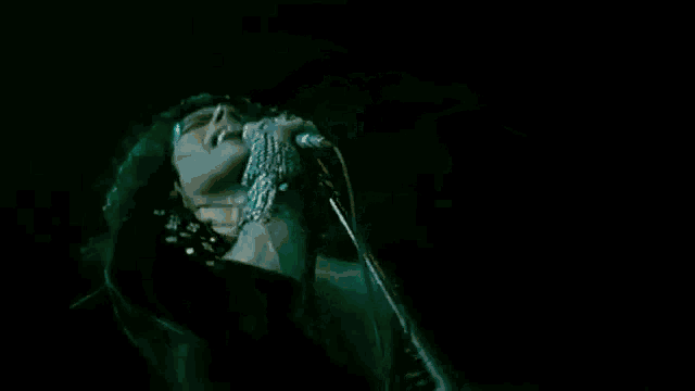 a man is holding a microphone in his hand and singing into it .