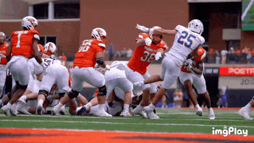 a football player with the number 25 on his jersey is being tackled