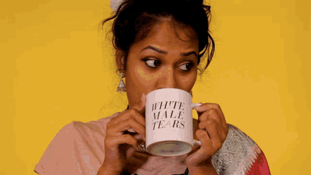 a woman is drinking from a white mug that says white male tears