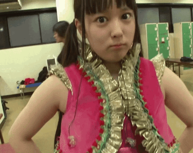 a girl wearing a pink and gold outfit with ruffles