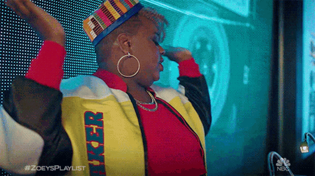 a woman wearing a hat and hoop earrings is dancing with her arms outstretched .