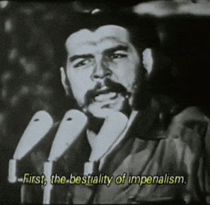 a man speaking into a microphone with the words " first the bestiality of imperialism " below him