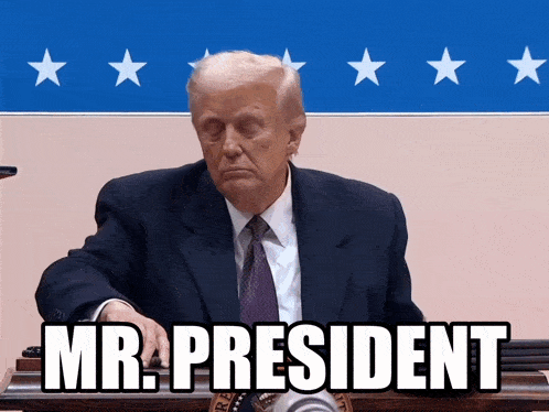 a man in a suit and tie is sitting in front of a sign that says " mr. president "