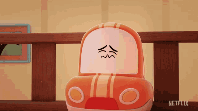 a toy car with a face drawn on it sits on a wooden railing with a netflix logo in the corner