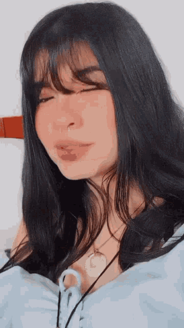 a woman with a nose ring is wearing a blue top