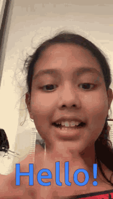 a young girl is saying hello with her finger