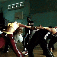a group of people are dancing in a room with a sign that says ccce on it