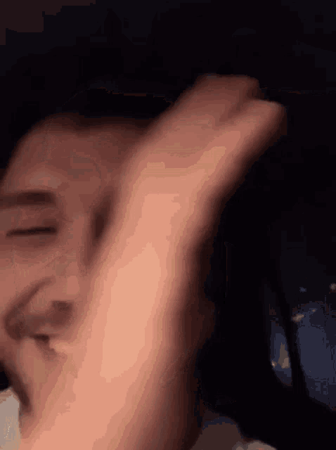 a close up of a person 's face with their hand on it .