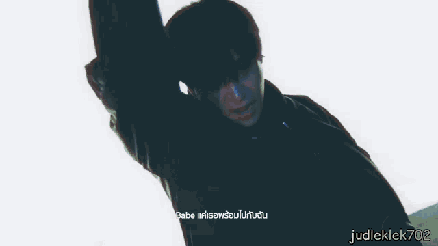 a man is dancing in front of a large white screen with judleklek702 on the bottom