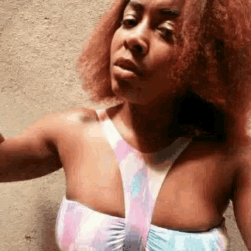 a woman with red hair is wearing a pink and blue bathing suit .