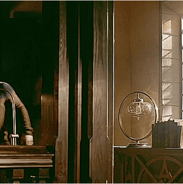 a person is doing a handstand in a room next to a lamp and a window .