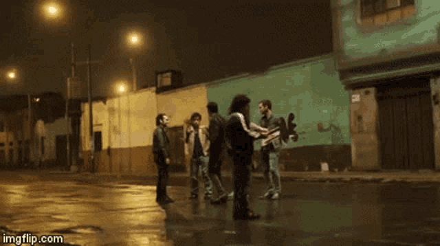 a group of people standing on a street at night with imgflip.com on the bottom