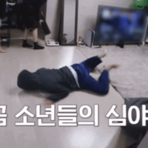 a person is laying on their back in a room with korean writing