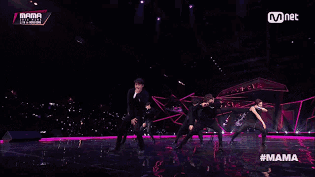 a group of men are dancing on a stage with the hashtag mama
