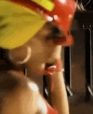 a close up of a woman wearing a red hard hat and a yellow hat