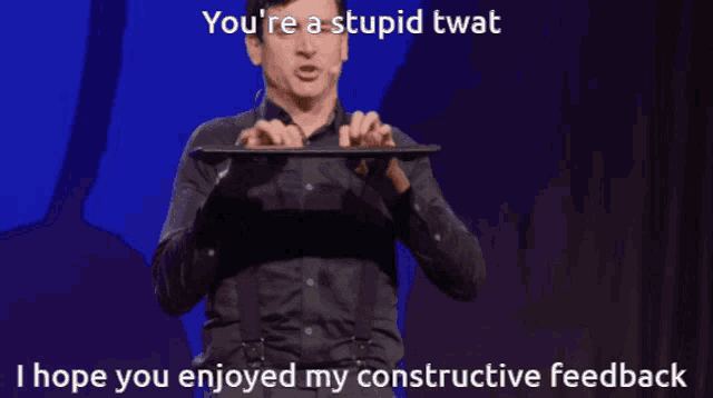 a man holding a keyboard with the words you 're a stupid twat i hope you enjoyed my constructive feedback below him