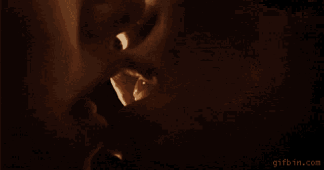 a close up of a woman 's lips being kissed by a man