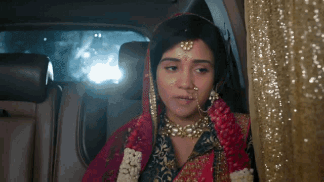 a bride is sitting in the back of a car