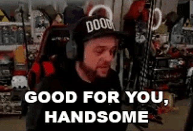 a man wearing headphones and a hat is saying `` good for you , handsome '' while sitting in a chair .